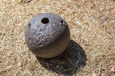 Gölge desen detaylarıyla saman zeminde paslı metal küre.