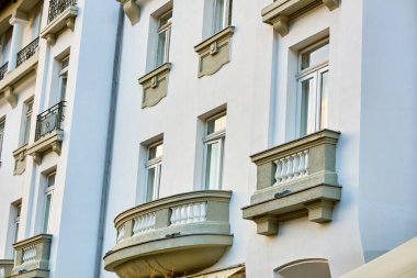 Balkonları ve klasik mimari unsurları olan zarif beyaz bina..