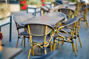 Şehir ortamında boş kafeterya masaları ve sandalyeler.