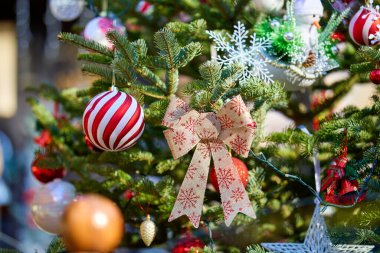 Kırmızı süslemeli ve parıltılı süslemelerle süslü Noel ağacı..