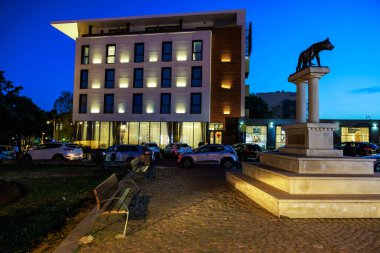 Şehir parkında modern bina ve heykel aydınlandı. 3 Mayıs 2025 Romanya.