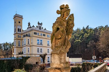 Taş heykeli ve güneşli orman manzaralı tarihi bir kale. 16 Mart 2025, Hruba Skala Şatosu, Çek Cumhuriyeti.