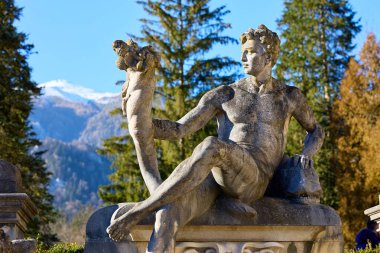 Dağlık arazide kornucopia ile antik erkek heykeli. 13 Aralık 2025 Sinaia Romanya.