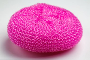 Pembe sünger beyaz arka planda duruyor. Sünger pembe ve bulanık bir dokusu var.