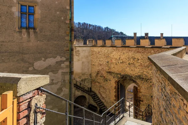 Güneşli avluda tarihi ortaçağ kale duvarları ve merdivenleri.