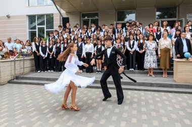 Lise öğrencileri mezuniyeti geleneksel dans gösterisiyle kutluyorlar. 2 Eylül 2024 Balti Moldova.