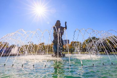 A statue of a man is standing in front of a fountain. The fountain is spraying water in the air. The sun is shining brightly, creating a beautiful atmosphere. October 27, 2024 Chisinau Moldova