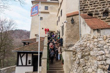 Bir grup insan binanın önündeki taş bir merdivende dikiliyorlar. 16 Aralık 2024 Bran Romanya.