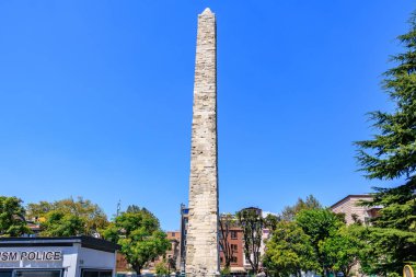 İstanbul Parkı 'ndaki antik dikilitaş, ağaçlı mavi gökyüzüne karşı. 12 Ağustos 2025 İstanbul Türkiye.