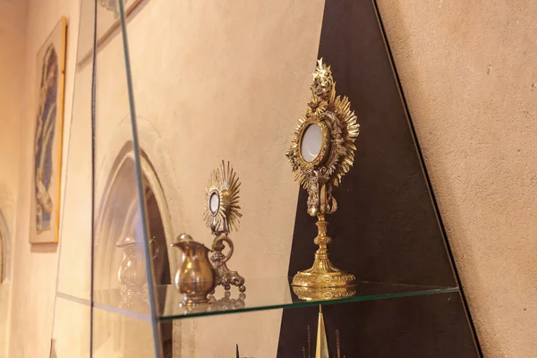 Tarihi bir ortamda cam raflarda sergilenen karmaşık altın dini eserler. 19 Mart 2025, Karlstejn, Çek Cumhuriyeti.