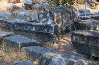 Taş oymaları ve açık havada kırık sütunlarla antik kalıntılar..