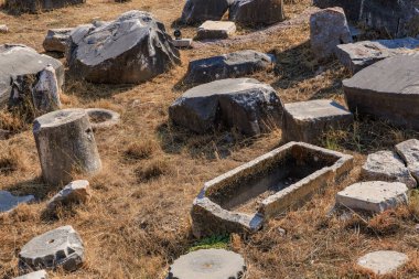 Güneşli bir günde taş kalıntıları ve çimlerle eski kalıntılar.