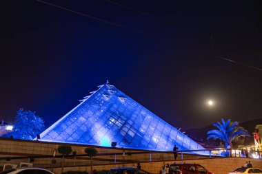 Geceleri insanlar ve arabalarla aydınlatılmış mavi piramit. 9 Ağustos 2025, 2 Bursa Türkiye.