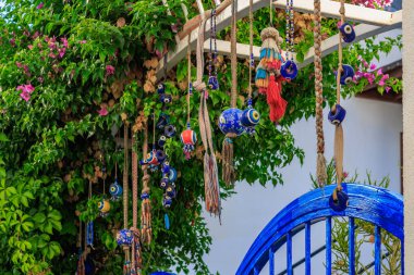 Bahçede asılı renkli Türk tılsımları ve boncuklar. 5 Ağustos 2025, Bodrum Türkiye.