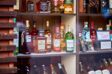 Vitrindeki raflarda sergilenen çeşitli içki şişeleri. 13 Aralık 2025 Sinaia Romanya.