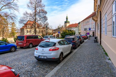 22 Mart 2025, Kutna Hora, Çek Cumhuriyeti 'nde park halindeki arabaların ve tarihi mimarinin olduğu Avrupa kentsel sokak sahnesi..