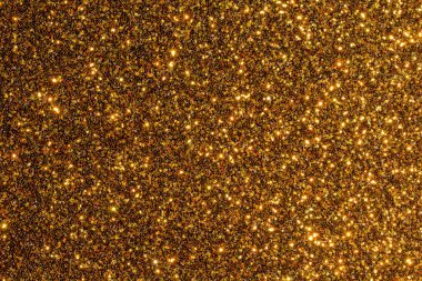 Pek çok küçük altın tanecikli altın parıltılı bir arka plan. Arka plan çok parlak ve parıltılı.