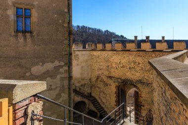 Ortaçağ kalesinin duvarları ve merdivenleri, temiz gökyüzünün altında, tarihsel ortamda..