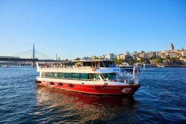 Arka planda Galata kulesiyle Boğaz 'da dolaşan kırmızı feribot. 10 Ağustos 2025, İstanbul Türkiye.