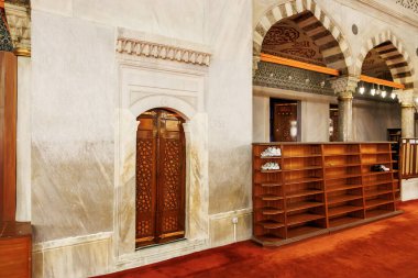 Ahşap raflar ve süslü kapılar olan cami içi. 11 Ağustos 2025, İstanbul Türkiye.