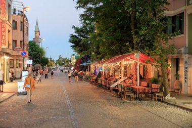 Açık hava kafeleri ve şehir ortamında yürüyen insanlarla dolu bir akşam manzarası. 11 Ağustos 2025, İstanbul Türkiye.