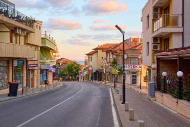 Gün batımında tarihi binalar ve dükkanlarla sakin bir Avrupa kentsel caddesi. 14 Ağustos 2025, Sozopol Bulgaristan.