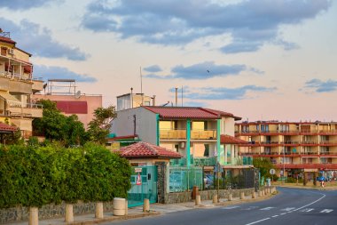 Gün batımında canlı gökyüzü ve yol yolu olan sahil apartmanları. 14 Ağustos 2025, Sozopol Bulgaristan.