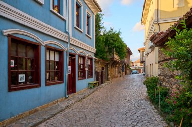 Büyüleyici kaldırım taşı caddesi gün batımında renkli tarihi binalarla dolup taşıyor. 14 Ağustos 2025, Sozopol Bulgaristan.