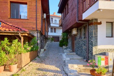Tarihi Avrupa köyünde gün batımında ahşap evleri olan güzel bir kaldırım taşı geçidi. 14 Ağustos 2025, Sozopol Bulgaristan.