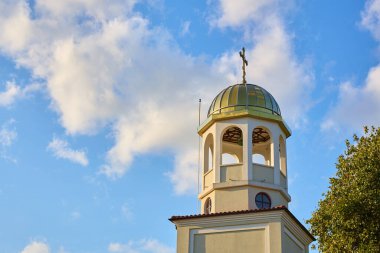 Mavi gökyüzüne karşı çaprazlı güneşli bir kilise çan kulesi.