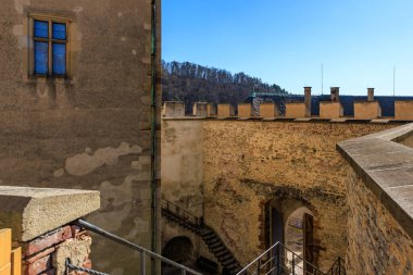 Güneşli bir günde merdivenleri ve kemerli tarihi taş kale avlusu.