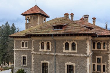 Kırmızı çatılı büyük tuğla bina. 15 Aralık 2024 Busteni Romanya.