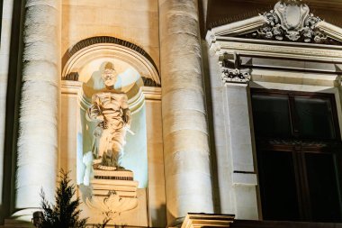 Geceleyin tarihi bina cephesinde klasik taş heykel yakıldı. 8 Mart 2025 Bükreş Romanya.