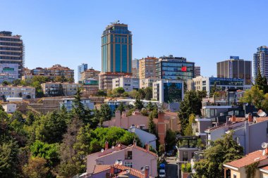 Gökdelenleri ve açık mavi gökyüzü altındaki konut binaları olan şehir manzarası. 12 Ağustos 2025 İstanbul Türkiye.