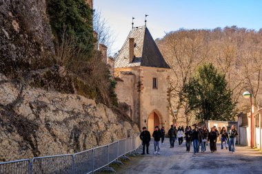 Ortaçağ şatosunu taş kuleyle gezen turistler manzara manzaralı bir yerde. 19 Mart 2025, Karlstejn, Çek Cumhuriyeti.