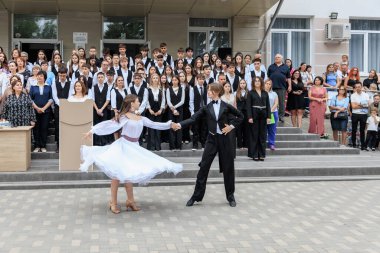 Genç beyaz dansçılar çeşitli izleyicilerle açık hava seremonisinde gösteri yapıyorlar. 2 Eylül 2024 Balti Moldova.