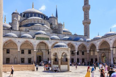 Turistler parlak bir günde tarihi mavi cami avlusunu keşfediyorlar. 12 Ağustos 2025 İstanbul Türkiye.