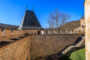 Manzaralı kuleleri ve merdivenleri olan ortaçağ taş kalesi. 19 Mart 2025, Karlstejn, Çek Cumhuriyeti.