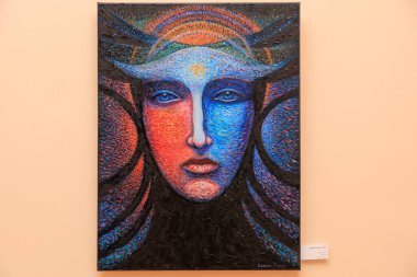 Mavi yüzlü ve kırmızı yüzlü bir kadın resmi. Resim soyut ve çok fazla detaya sahip. 12 Mart 2024 Balti Moldova