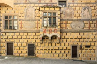 Rönesans 'tan esinlenilmiş, sıva kabartmaları ve simetrik tasarımı olan mimari bir cephe. 20 Mart 2025, Cesky Krumlov, Çek.