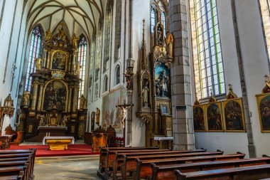 Gotik katedralin içini boyalı camlar ve ahşap sıralarla süsleyin. 20 Mart 2025, Cesky Krumlov, Çek.