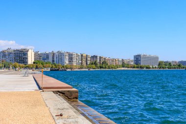 İskelesi ve arka planında bir şehir olan güzel mavi bir okyanus. Su sakin ve gökyüzü berrak. 8 Ağustos 2024 Selanik Yunanistan