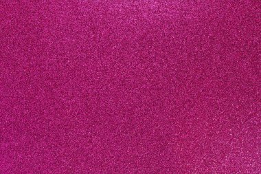 Pembe bir arka plan ve bir sürü parıltı. Parıltı farklı boyutlarda ve her yere saçılmış.