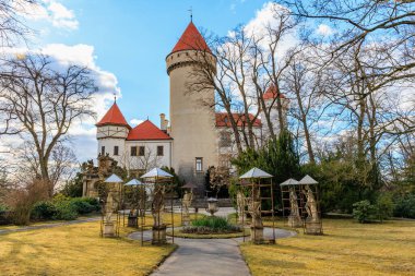 Huzurlu ormanlık alanda berrak mavi gökyüzü olan tarihi bir Avrupa kalesi. 17 Mart 2025, Konopiste Şatosu, Çek Cumhuriyeti.