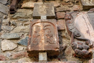 Melek heykeli ve arma amblemi ile yıpranmış duvara antik taş oymalar. 17 Mart 2025, Konopiste Şatosu, Çek Cumhuriyeti.