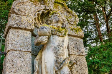 Yosun kaplı taş heykel, ormandaki tarihi ve sanatsal detaylarla dolu. 17 Mart 2025, Konopiste Şatosu, Çek Cumhuriyeti.