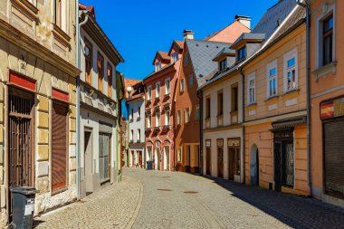 Renkli binaları ve kaldırım taşı yolu olan tarihi Avrupa caddesi. 18 Mart 2025, Madalyon, Çek Cumhuriyeti.