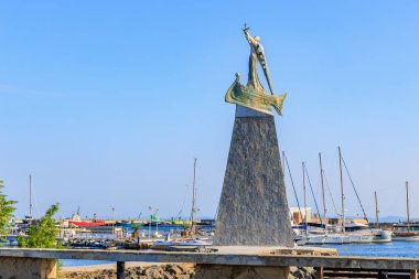 Açık bir günde arka planda tekneler olan Varna Limanı 'ndaki deniz kızı heykeli. 1 Ağustos 2025, Nessebar Bulgaristan.