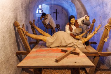 Kadın araştırmacı ve zindanda tutuklu bulunan bir ortaçağ işkence sahnesi. 18 Mart 2025, Madalyon, Çek Cumhuriyeti.