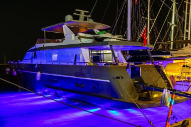 Lüks bir yat, gece parlak mavi sualtı ışıklarıyla demirlemiş. 5 Ağustos 2025, Bodrum Türkiye.